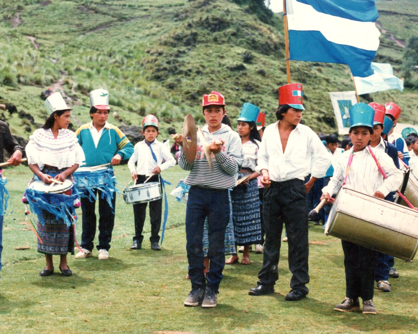 Estudiantes con banderas e instrumentos musicales durante un acto cívico. - El sueño guatemalteco lo construimos juntos. XumaK